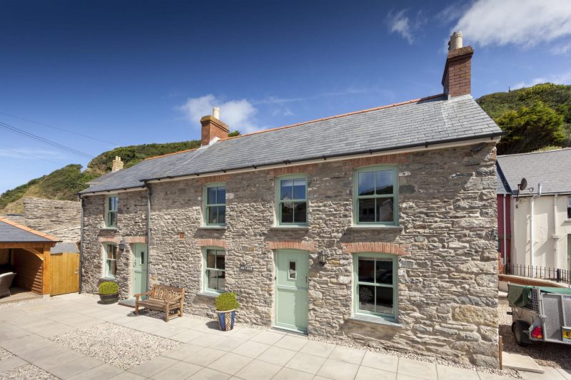 Stone cottage with sage green uPVC sash windows and matching front door
