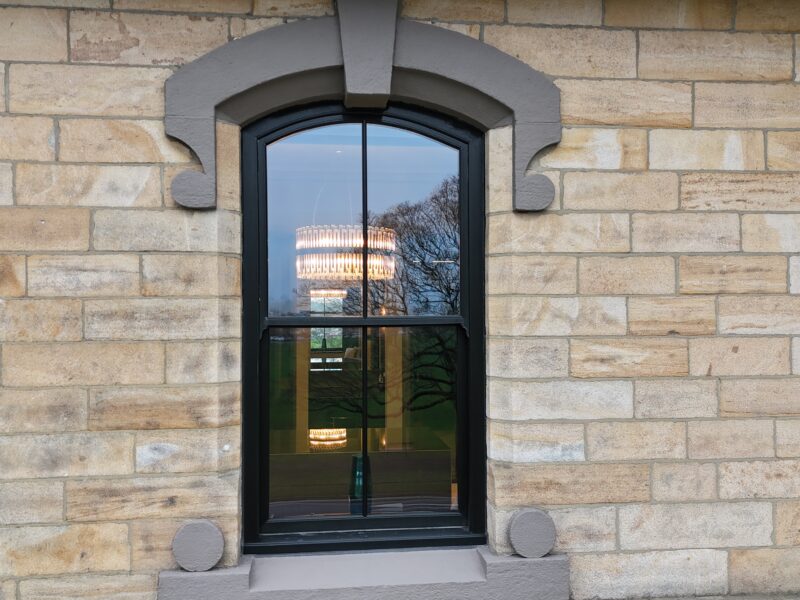 Black woodgrain sash windows complementing traditional architecture