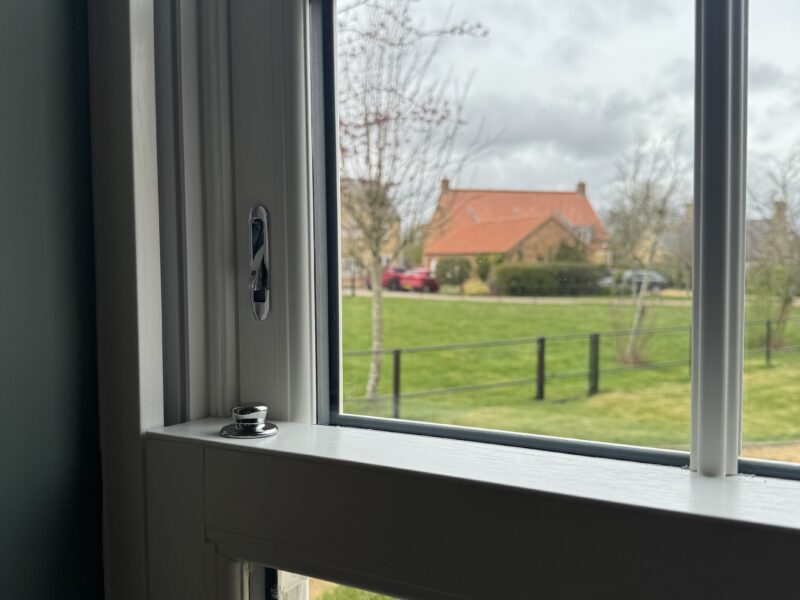 Internal view of Georgian-style uPVC sash window with white woodgrain finish and traditional bar layout