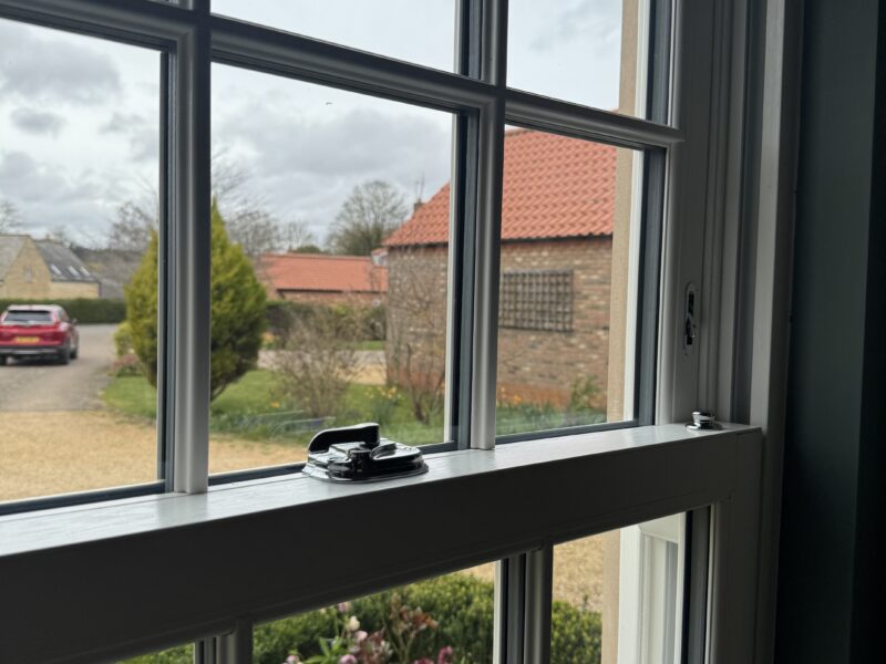 Close-up of uPVC sliding sash window showing woodgrain finish