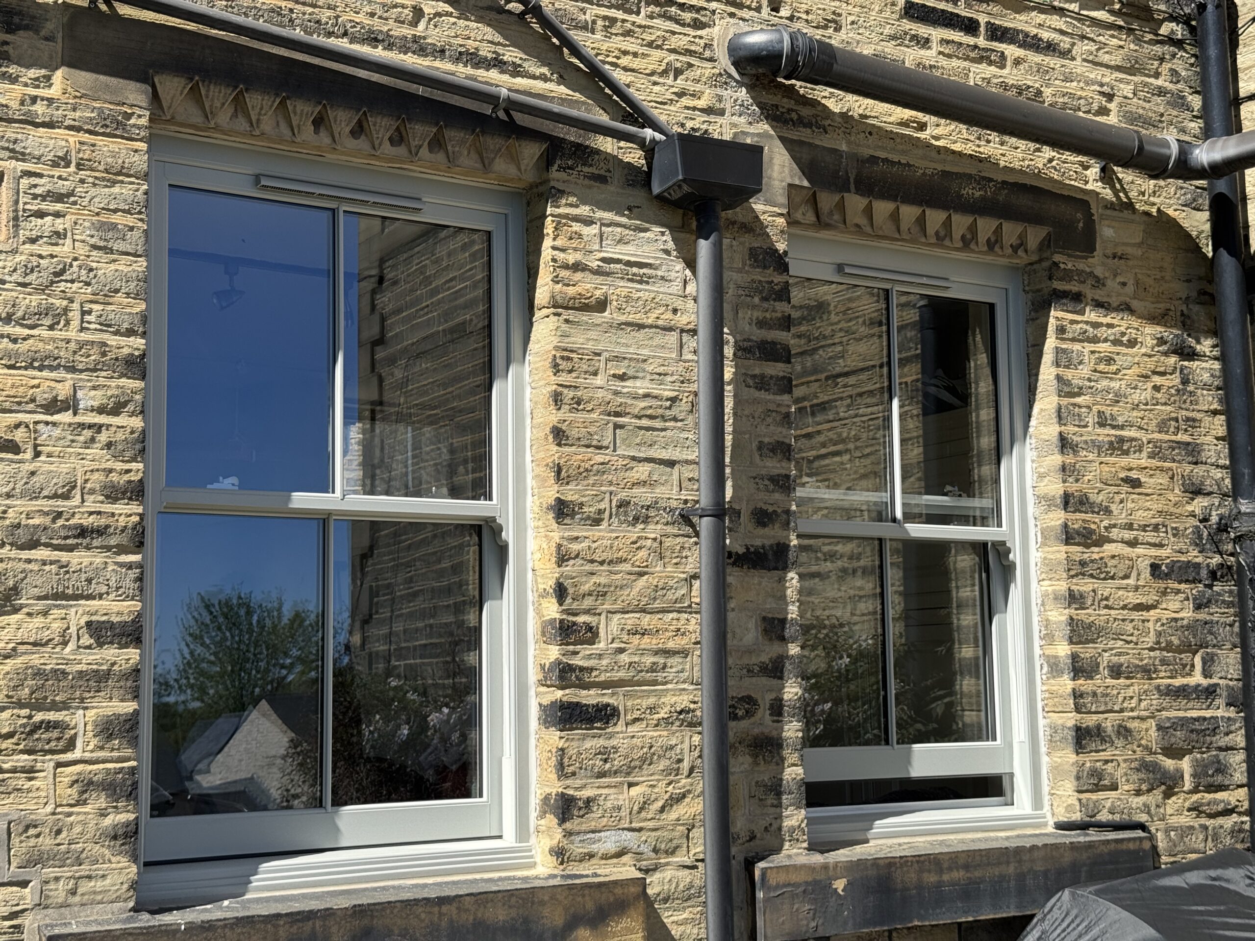 Arched Agate Grey sash window with heritage detailing on stone property