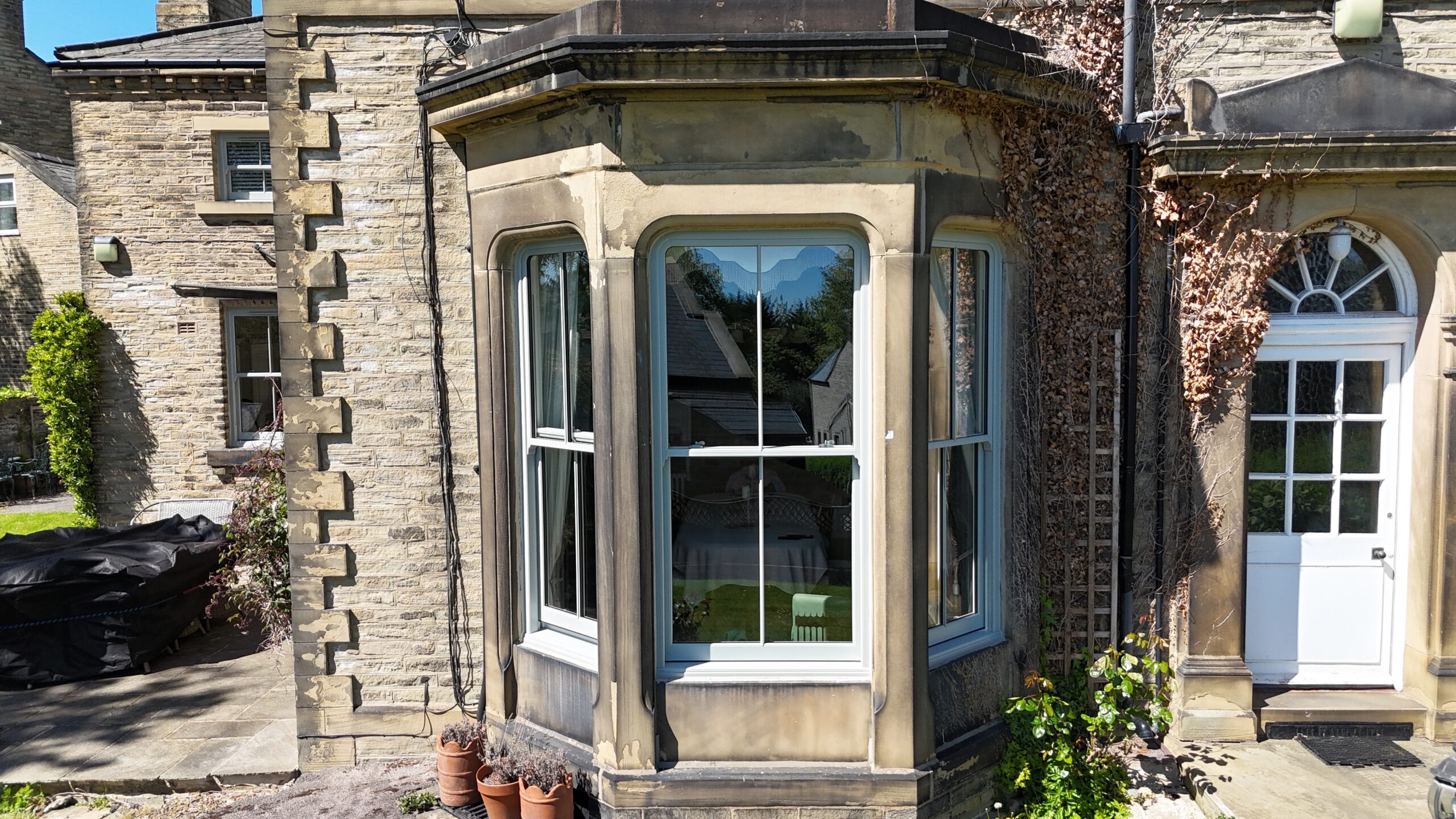Agate Grey sash bay window with slim midrail and heritage hardware