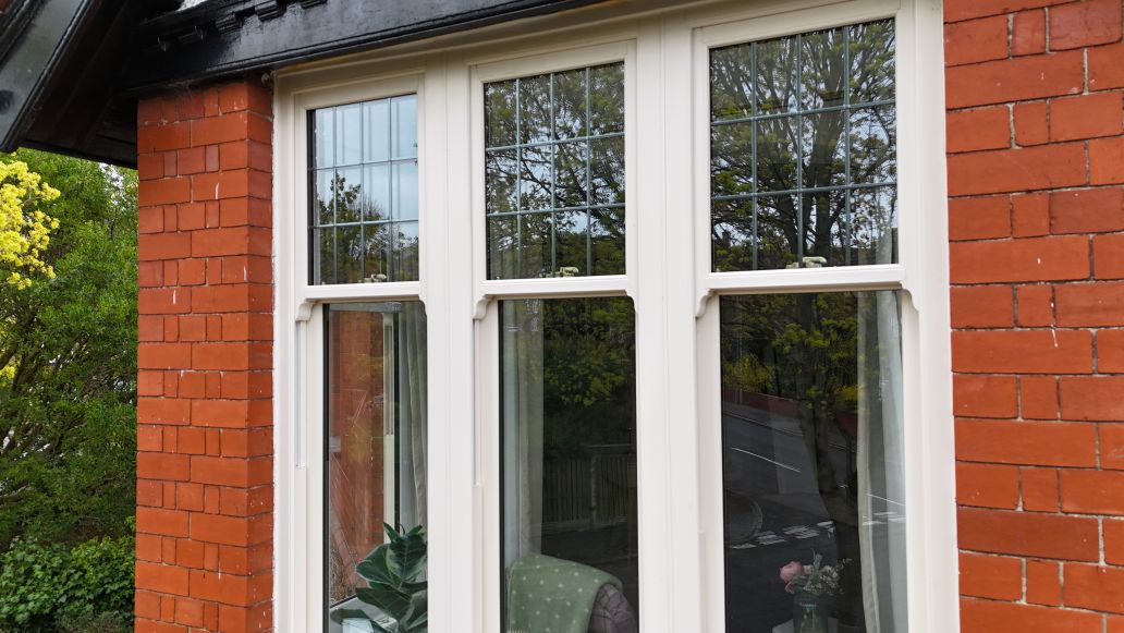 Heritage-style uPVC sash windows with astragal bars on a red brick property